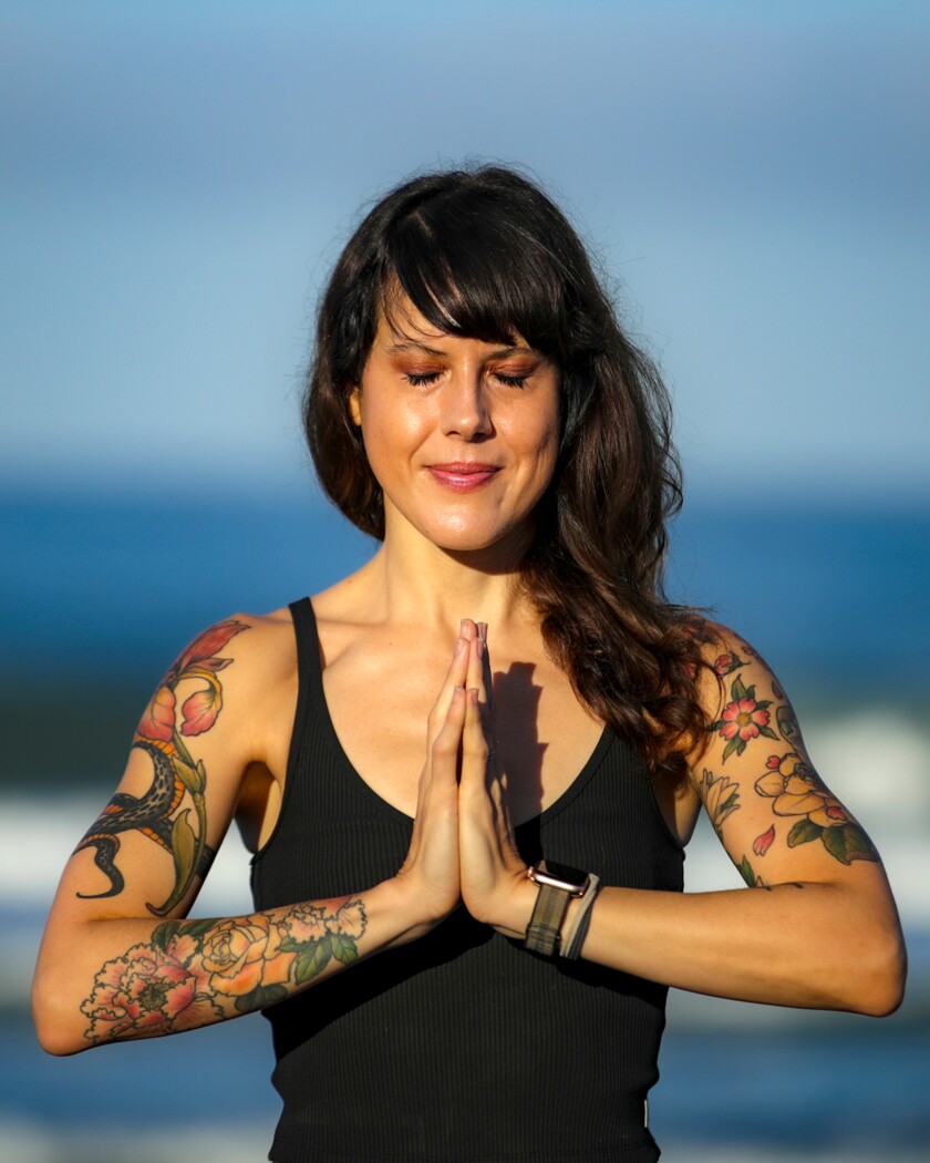 Yoga teacher Laura Schwartz with her hands clasped in a meditative pose.