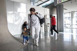 San Diego, California - May 20: Tatiana, 29, of Colombia, takes her one-year-old son Alejandro's hand and heads to a flight for Denver at the San Diego International Airport on Monday, May 20, 2024 in San Diego, California. Tatiana said she came to the United States for a better future for her son and for him to have "another kind of life without so much danger." She said she stayed a night in a shelter before finding a flight out of the city. (Ana Ramirez / The San Diego Union-Tribune)
