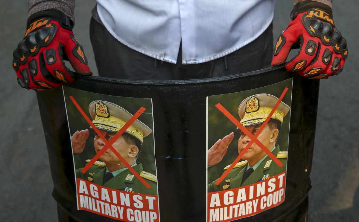 FILE - An anti-coup protester displays defaced images of Commander in chief, Senior Gen. Min Aung Hlaing in Mandalay, Myanmar, Wednesday, March 3, 2021. As Feb. 1, 2023, marks two years after Myanmar’s generals ousted Aung San Suu Kyi’s elected government, thousands of people have died in civil conflict and many more have been forced from their homes in a dire humanitarian crisis. (AP Photo, File)