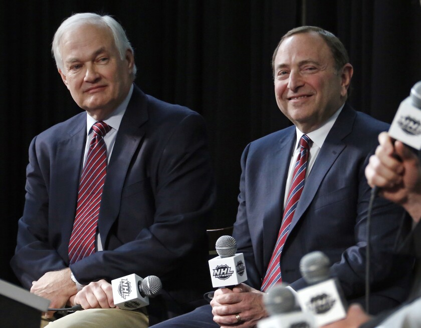 FILE - In this Jan. 24, 2015, file photo, NHL Player's Association executive director Donald Fehr, left, and NHL Commissioner Gary Bettman attend a news conference at Nationwide Arena in Columbus, Ohio. Given the gravity of the pandemic and the abrupt decision to place the NHL season on pause in March, it did not take Bettman and Fehr long to realize they were going to have to work together if play was to resume any time soon. (AP Photo/Gene J. Puskar, File)
