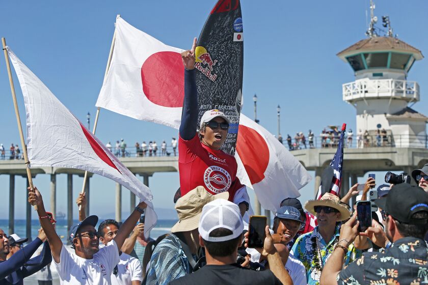 Huntington BeachOs Kanoa Igarashi, of Team Japan, carried by supporters as he celebrates winning the ISA World Surfing Games individual menOs final at Huntington Beach Pier on Saturday. (Kevin Chang / Daily Pilot)