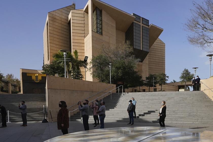 ARCHIVO - Gente asiste a un acto de recuerdo ante la catedral de Nuestra Señora de Los Ángeles, en Los Ángeles, el 19 de enero de 2021. (AP Foto/Damian Dovarganes, Archiv)