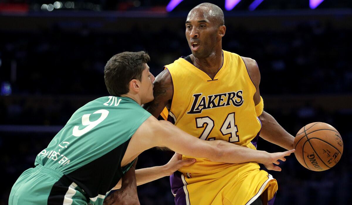 Maccabi Haifa’s Yiftach Ziv, left, defends Lakers' Kobe Bryant during the second half of a preseason basketball game on Sunday.