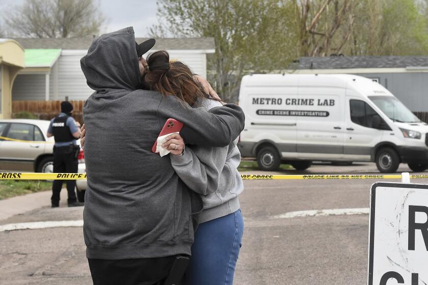Freddy Marquez kisses the head of his wife, Nubia Marquez, near the scene where her mother and other family members were killed in a mass shooting early Sunday, May 9, 2021, in Colorado Springs, Colo. The suspected shooter was the boyfriend of a female victim at the party attended by friends, family and children. He walked inside and opened fire before shooting himself, police said. Children at the attack weren’t hurt and were placed with relatives. (Jerilee Bennett/The Gazette via AP)