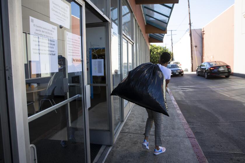 HOLLYWOOD, CA OCTOBER 25, 2019: The nonprofit Youth Policy Institute is shutting down today, leaving its hundreds of staff members without jobs and tens of thousands of clients without services. Staff members carry their belongings to their car out of the now closed Youth Policy Institute in a strip mall in Hollywood. Staff members did not want to speak with journalists. (Francine Orr/ Los Angeles Times)