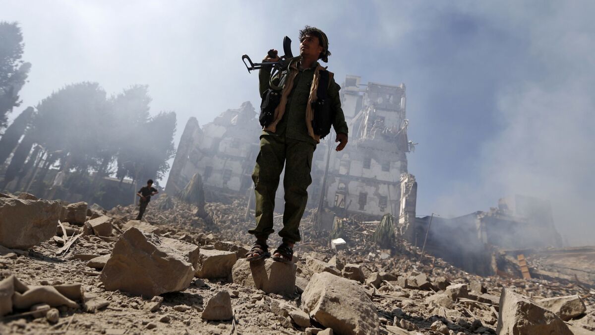 Houthi rebel fighters, who are are longtime opponents of Al Qaeda in Yemen, inspect the damage after a reported airstrike by the Saudi-led coalition targeted the presidential palace in Sana.
