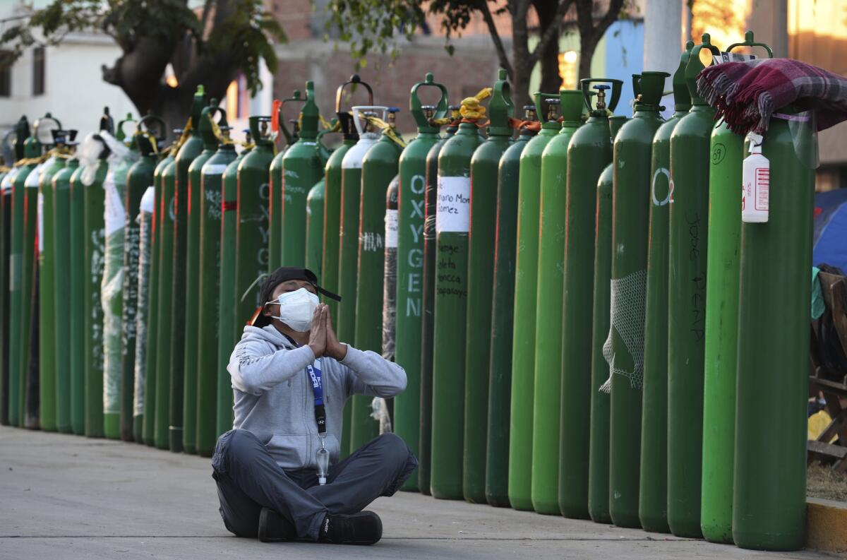 Alejandro Ccasa reza después de esperar días junto a un tanque de oxígeno vacío