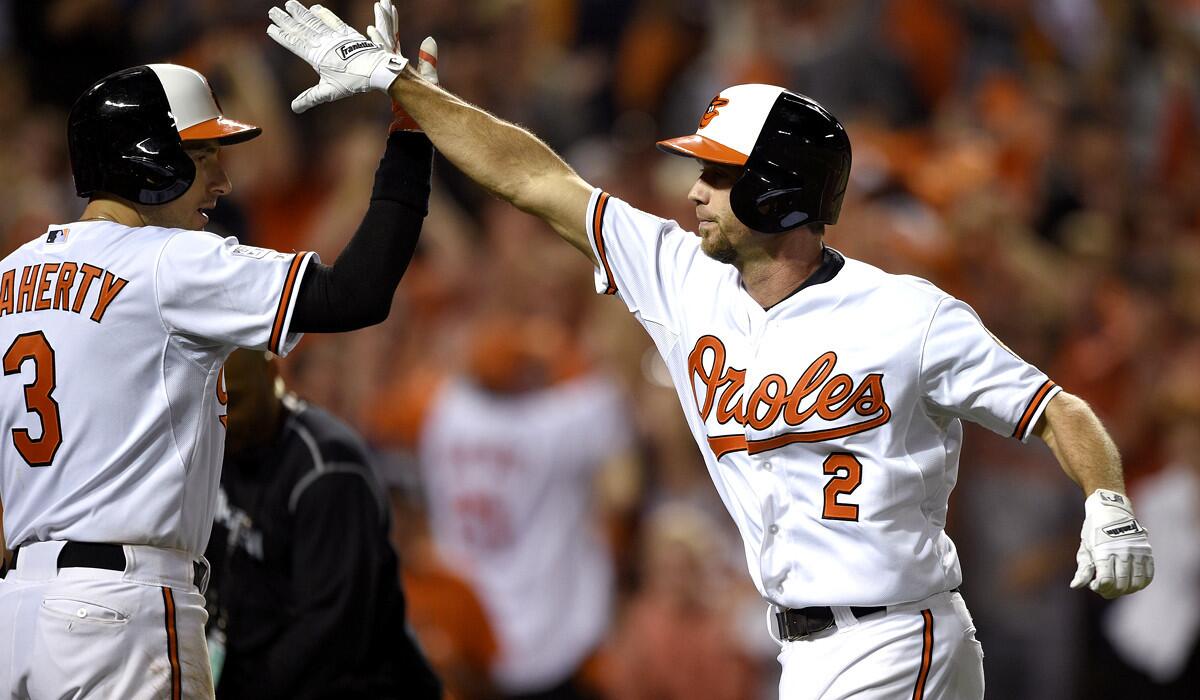 Orioles shortstop J.J. Hardy (2) gets a high-five from teammate Ryan Flaherty (3) after hitting a home run against the Tigers in the seventh inning Thursday night in Baltimore.