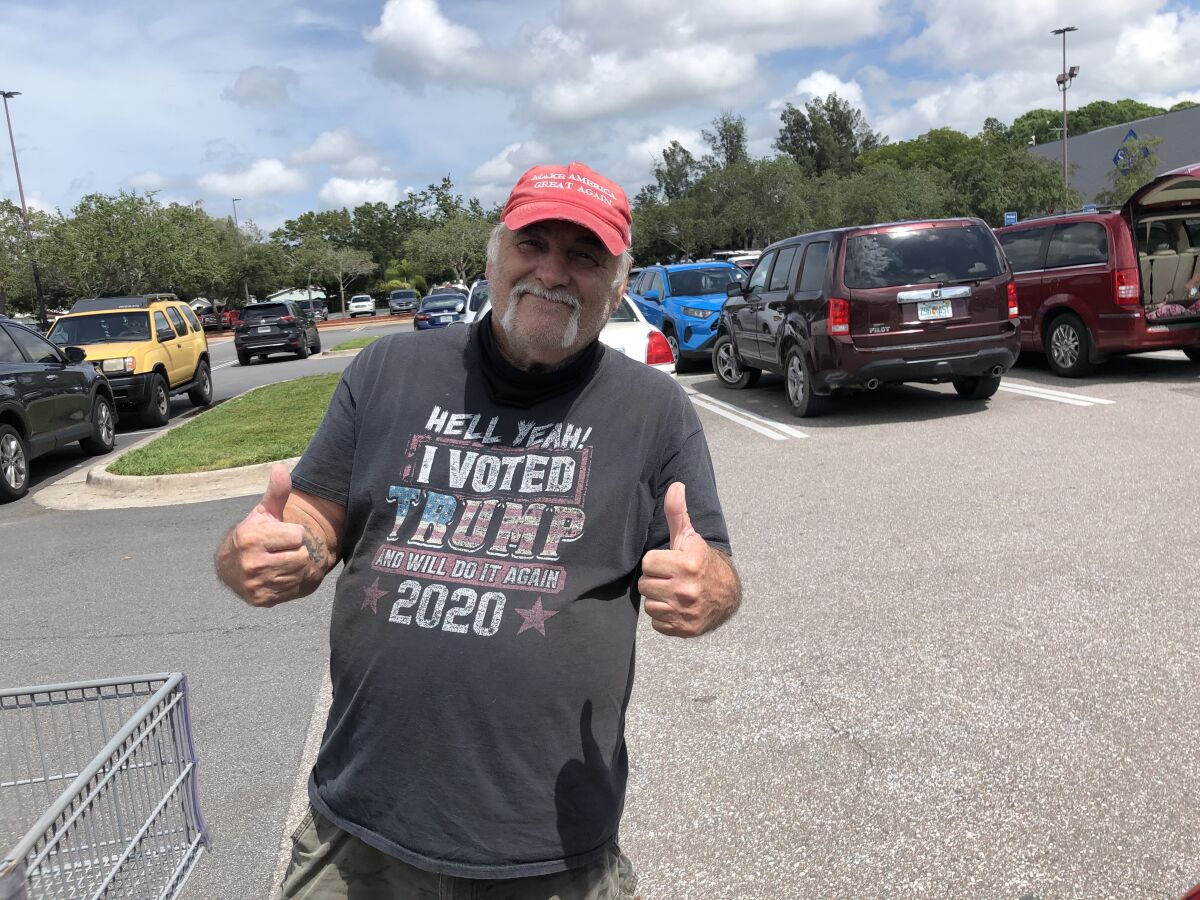 Joseph Wieder of Pinellas Park, Fla., wearing a "Make America great again" cap and a pro-Trump T-shirt, gives two thumbs up.