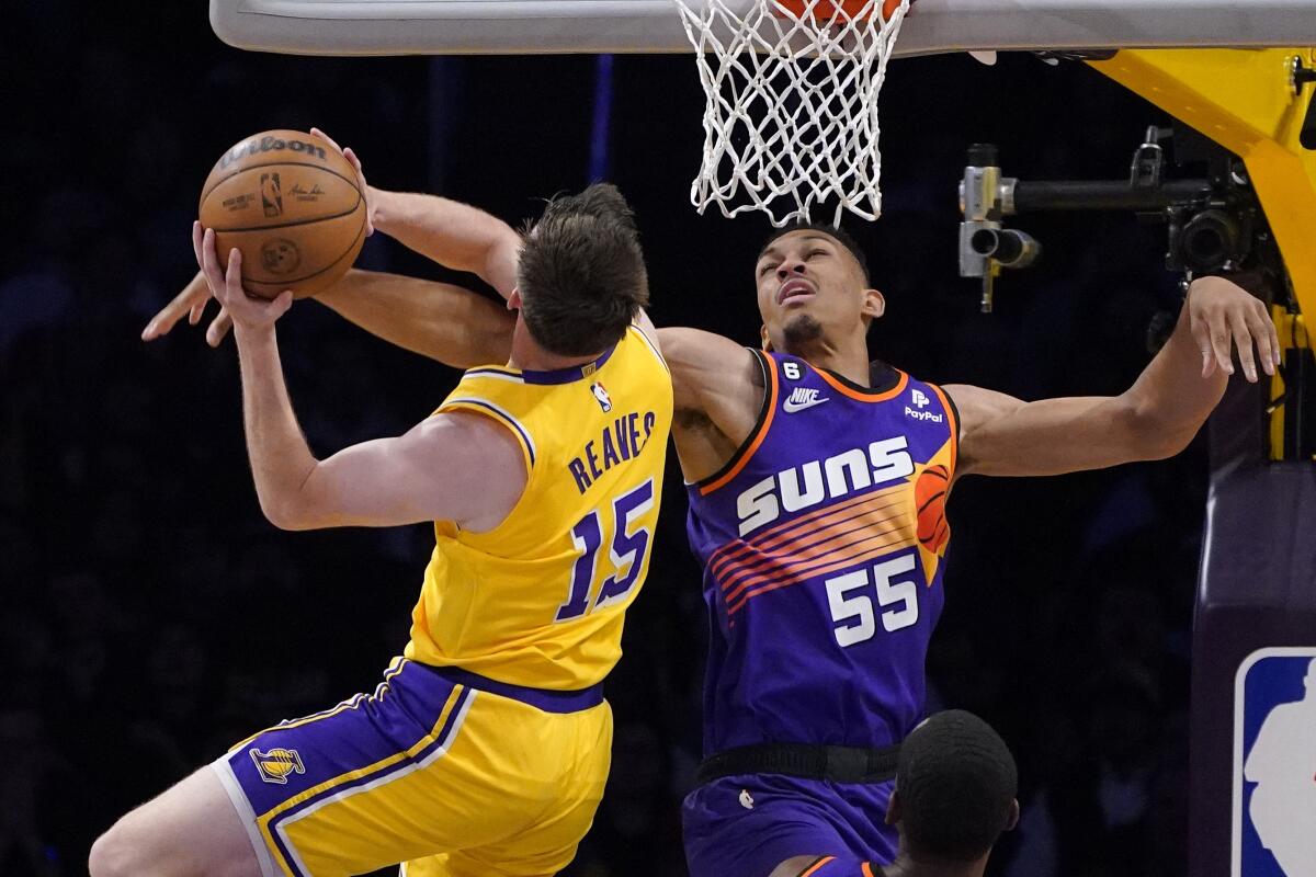 Los Angeles Lakers guard Austin Reaves, left, shoots as Phoenix Suns forward Darius Bazley defends during the first half of an NBA basketball game Wednesday, March 22, 2023, in Los Angeles. (AP Photo/Mark J. Terrill)