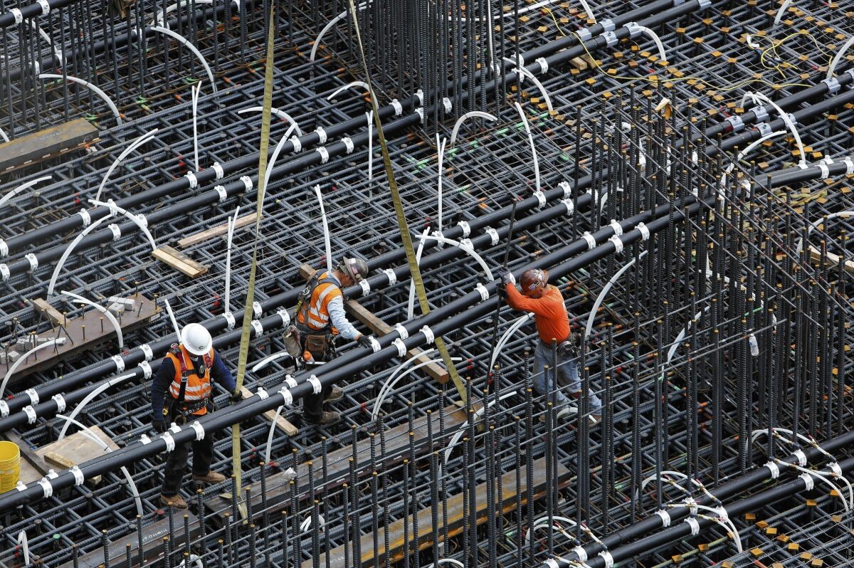 Workers position pipes in the 18-foot-deep pit that will be filled with concrete to form the foundation for the New Wilshire Grand skyscraper at 7th, Wilshire and Figueroa. For the tallest structure to be built west of the Mississippi, the concrete will be poured without interruption.