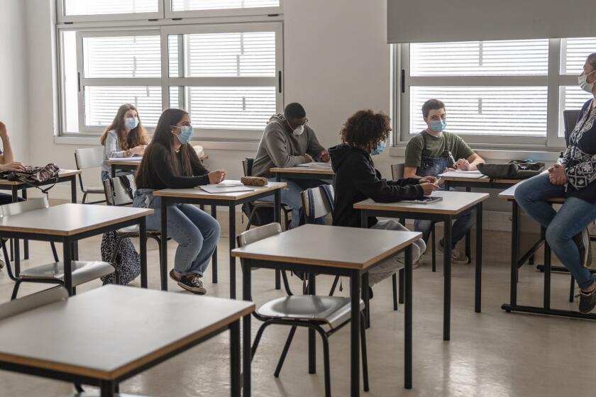 CASCAIS, PORTUGAL - MAY 18: High school students and their teacher wear mandatory protective masks during class in the Agrupamento de Escolas Frei Gonçalo de Azevedo during the COVID-19 Coronavirus pandemic on May 18, 2020 in Cascais, Portugal. 200.000 students are returning to school in Portugal today as part of new and more relaxed measures adopted by the government after the country's state of emergency was downgraded to state of calamity permitting certain non-essential services and commercial activities to resume as the coronavirus (COVID-19) epidemic appears to be under control. (Photo by Horacio Villalobos#Corbis/Corbis via Getty Images)