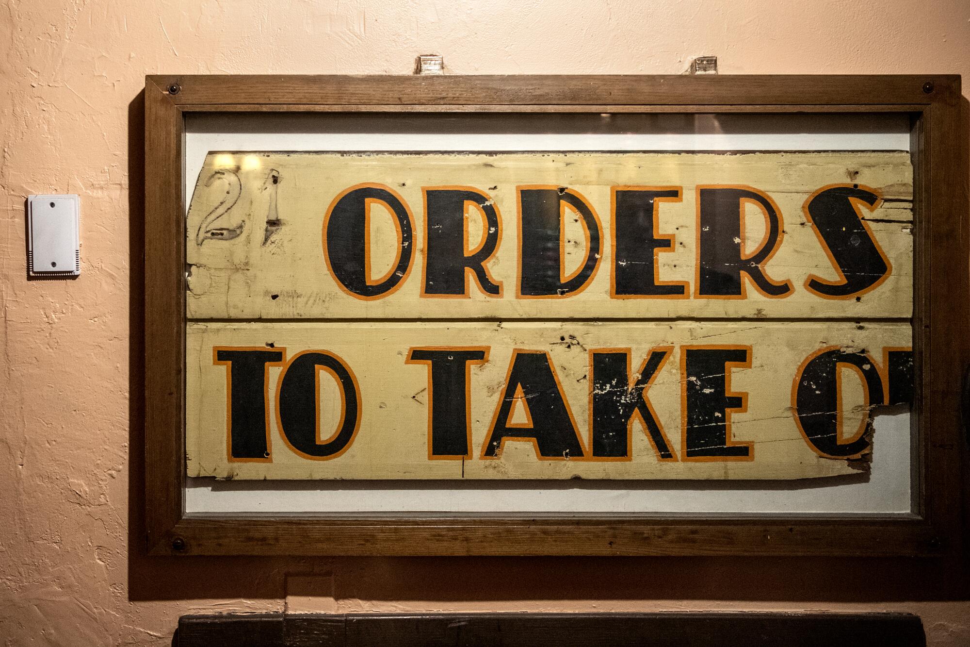 A vintage sign hanging on the wall of El Cholo.