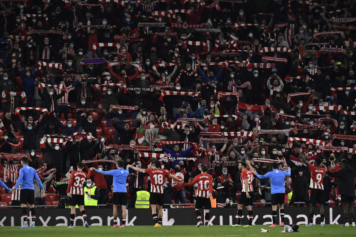 Athletic Bilbao players celebrate their victory over Real Madrid at the end of the Spanish Copa del Rey quarter final soccer match between Athletic Bilbao and Real Madrid at the San Mames stadium in Bilbao, Spain, Thursday, Feb. 3, 2022. (AP Photo/Alvaro Barrientos)