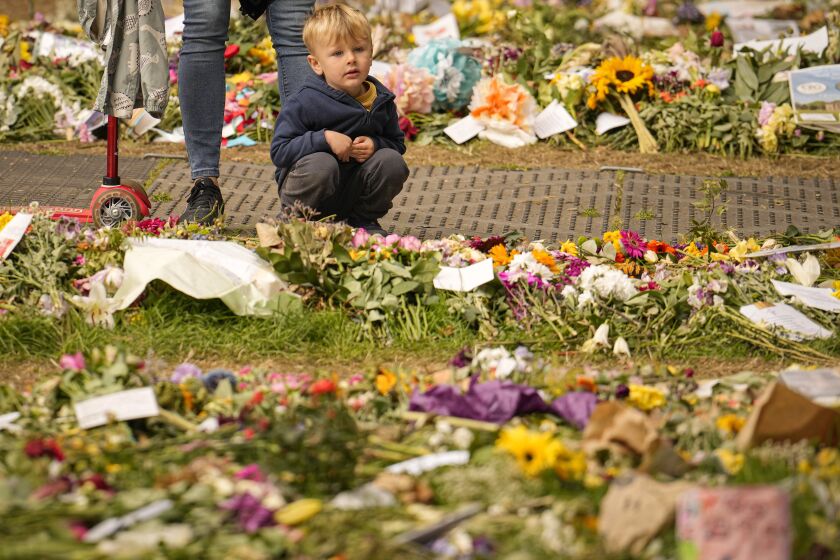 Gente deja ofrendas florales a la reina Isabel II al día siguiente de su funeral en el Green Park de Londres, martes 20 de setiembre de 2022. (AP Foto/Vadim Ghirda)