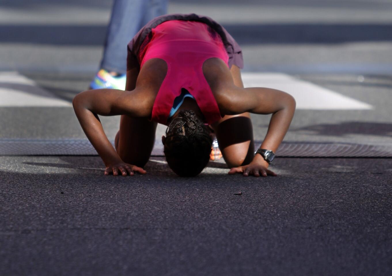 Amane Gobena of Addis Ababa, Ethiopia, puts her head on the ground after winning the women's division of the 29th annual L.A. Marathon.