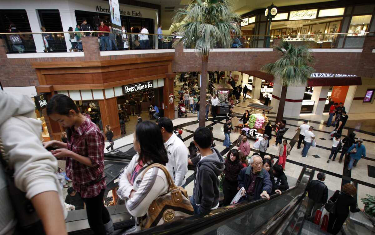 People go  up an escalator at the Glendale Galleria.
