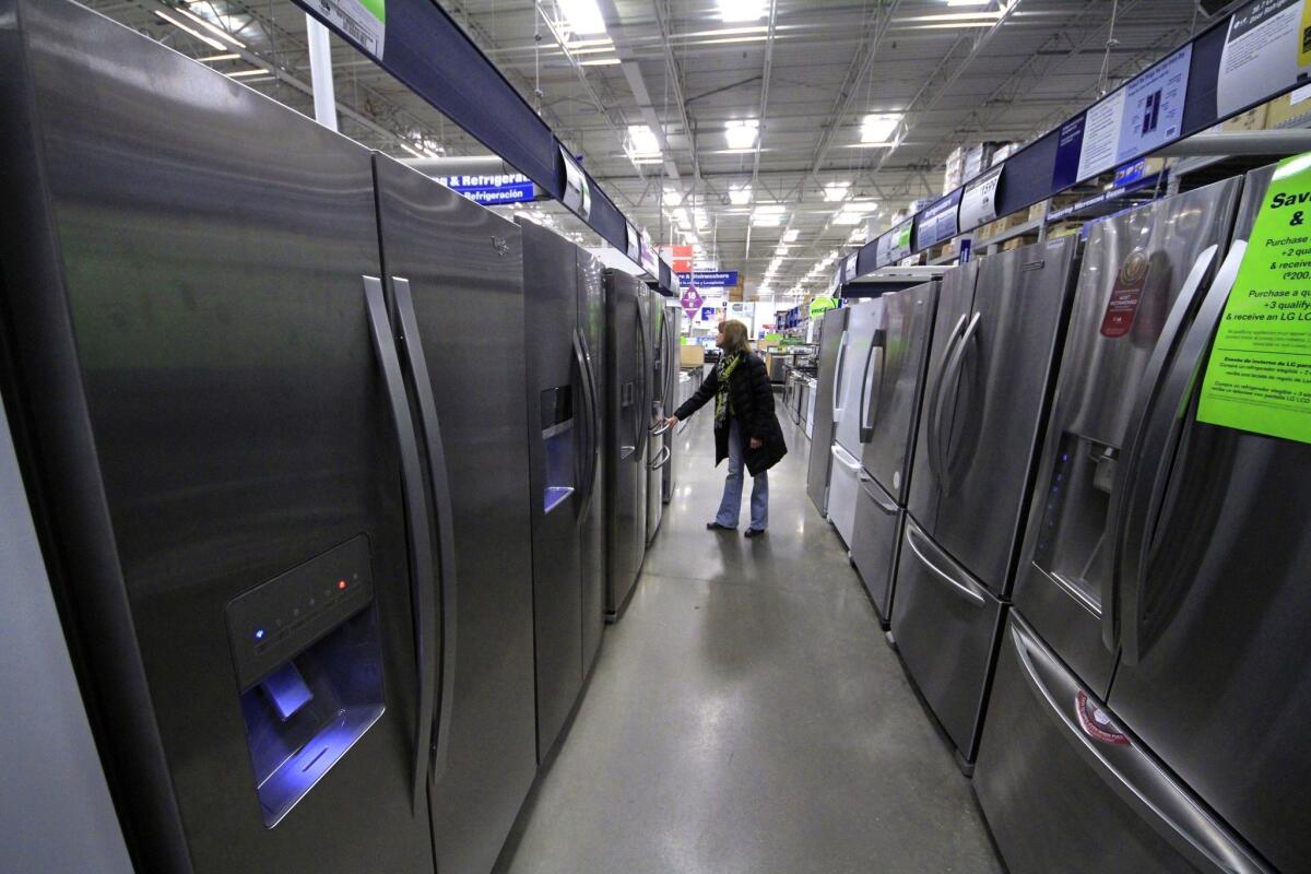 A woman walks through a display of refrigerators at a Lowe's store in Cranberry Township, Pa.