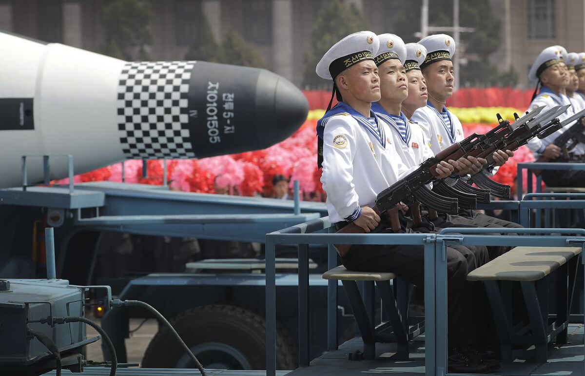North Korean sailors ride in a parade with a missile