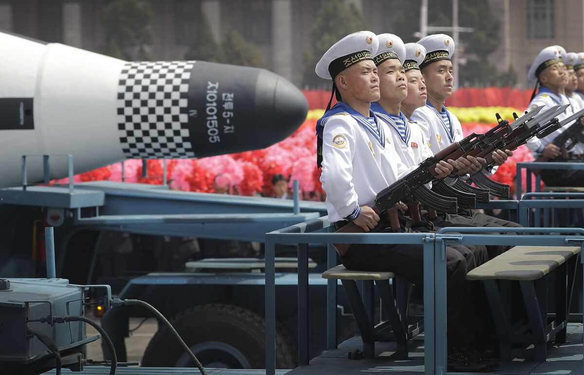 North Korean sailors ride in a parade with a missile