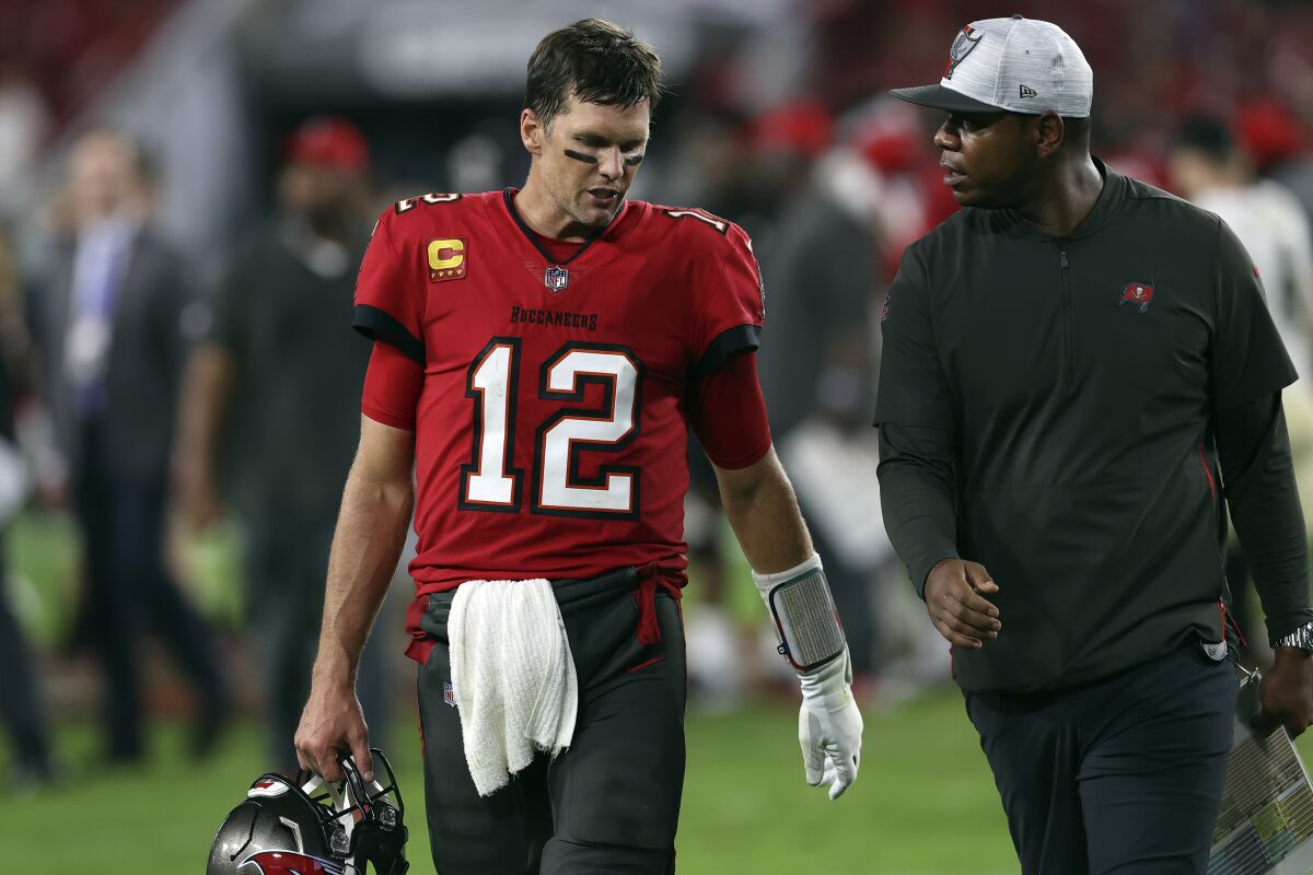 Tampa Bay Buccaneers quarterback Tom Brady leaves the field with offensive coordinator Byron Leftwich.