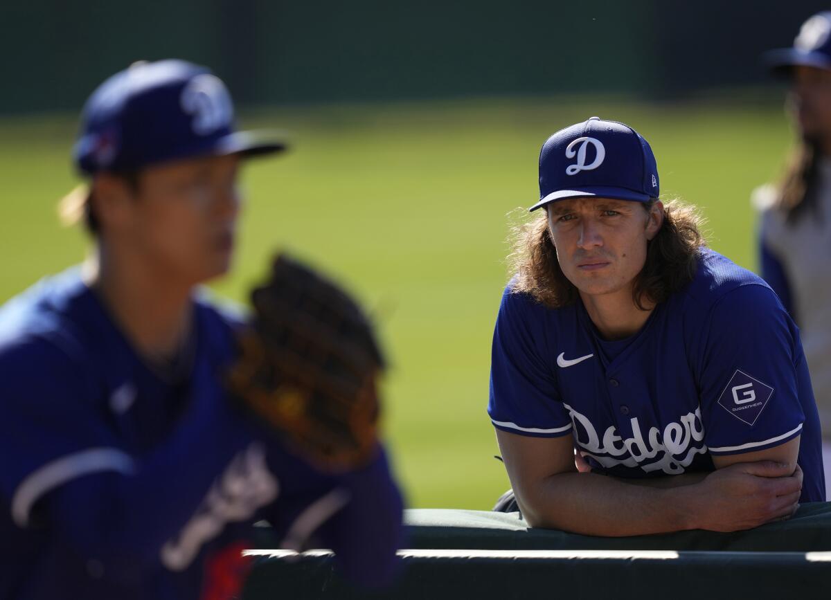 Dodgers pitcher Tyler Glasnow watches as Yoshinobu Yamamoto throws during a spring training workout at Camelback Ranch.