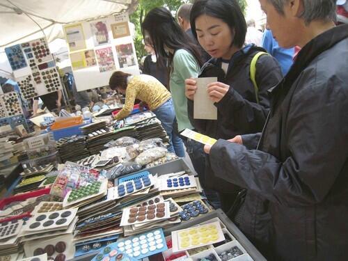 Shoppers look over the vintage buttons for sale at Eric Hebert's stall at the Puces de Vanves flea market on Paris' southern edge.
