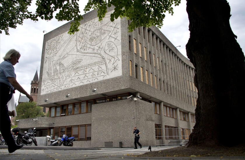 People pass Picasso's mural artwork "The Fisherman" in Oslo. A car bomb ravaged the buildings on which the murals were sandblasted.