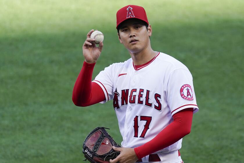 Los Angeles Angels starting pitcher Shohei Ohtani (17) throws a ball to fans as he warms up.