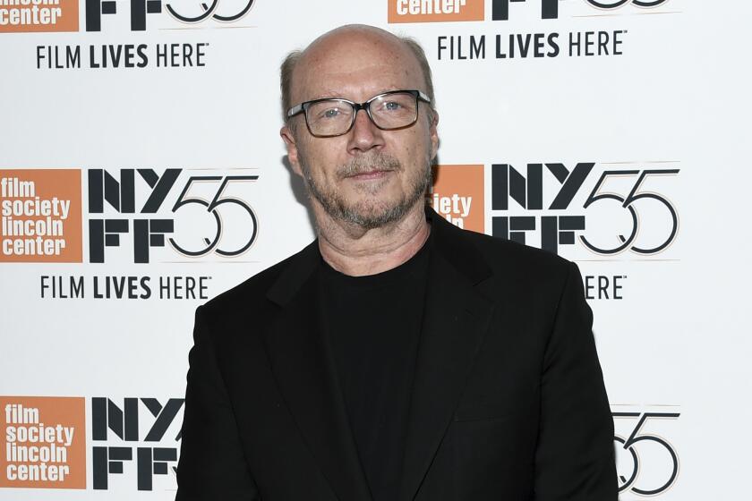 A bald man wearing glasses and a black shirt and suit