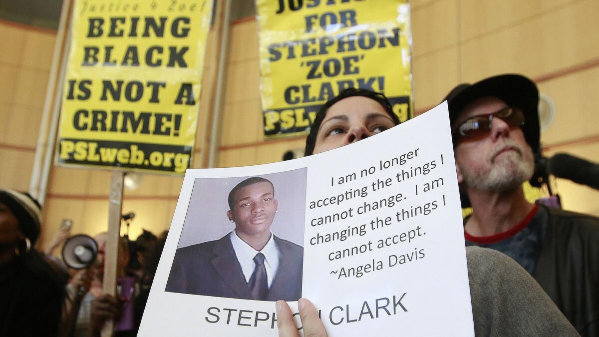 At a March 2018 protest, Anita Ross holds a photo of 22-year-old Stephon Clark, who was fatally shot by police.