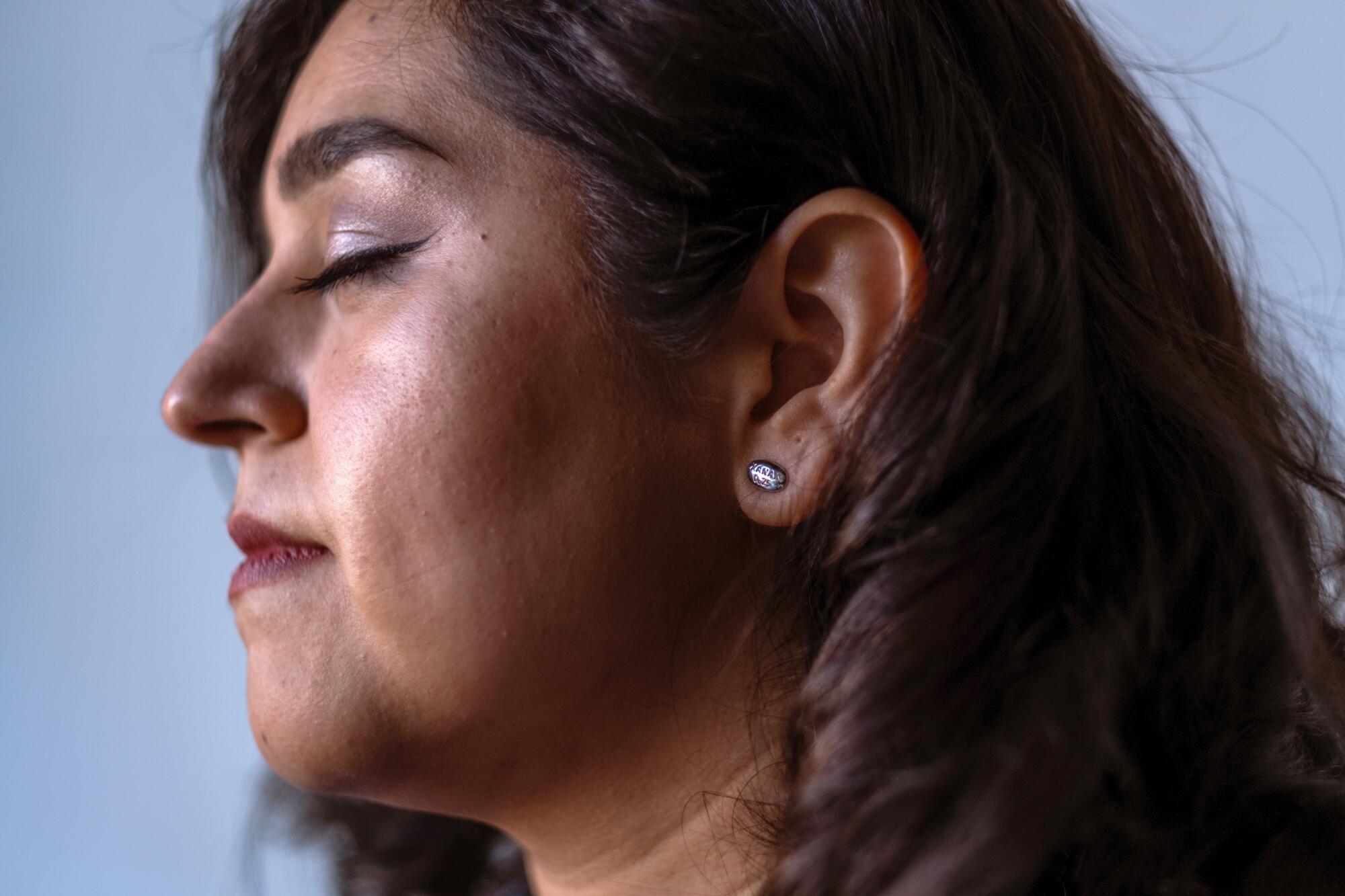 A portrait of entrepreneur Rosa Valdes wearing her Xanax earrings.