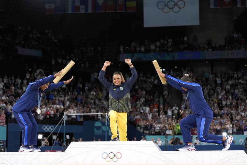 La medalllista de plata Simone Biles (izquierda) y la medallista de bronce Jordan Chiles se inclinan ante la campeona brasileña Rebeca Andrade tras ganar la medalla de oro en el ejercicio de piso de los Juegos Olímpicos de París, el lunes 5 de agosto de 2024. (AP Foto/Abbie Parr)