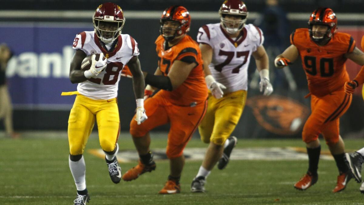 USC running back Aca'Cedric Ware (28) breaks through the line and heads up field against Oregon State in the second half on Saturday.