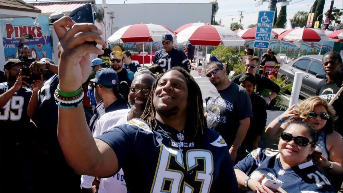 Chargers guard Donavon Clark takes selfies with fans at Pink's Hot Dogs in Los Angeles on March 14.