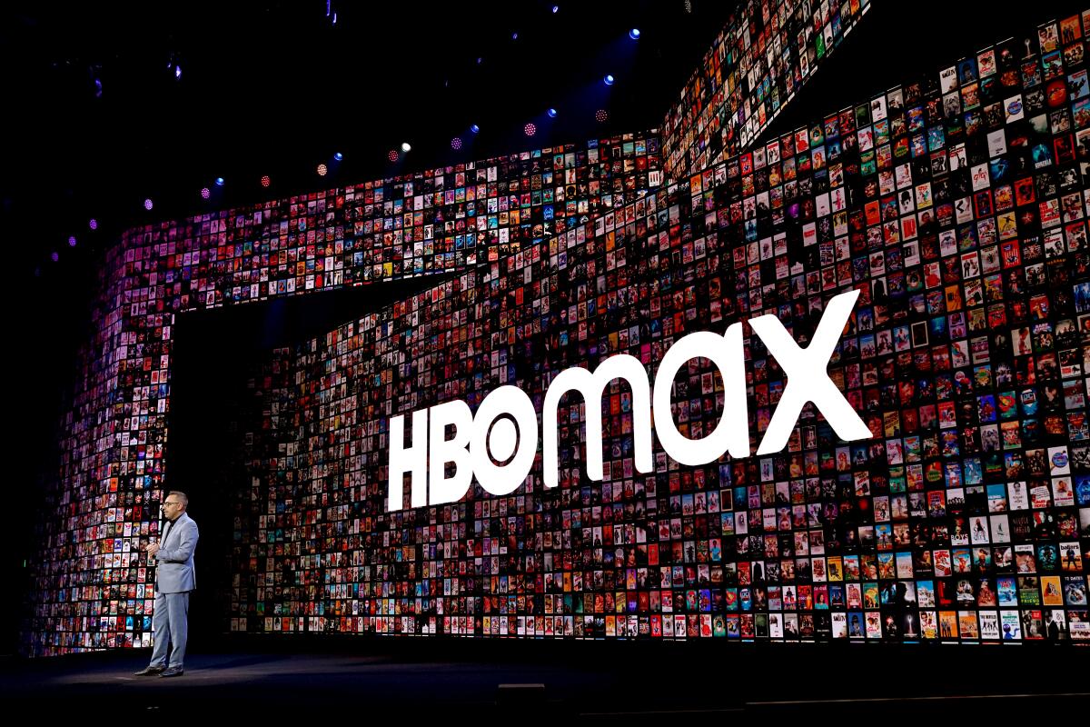 A man speaks onstage in front of the HBO Max logo