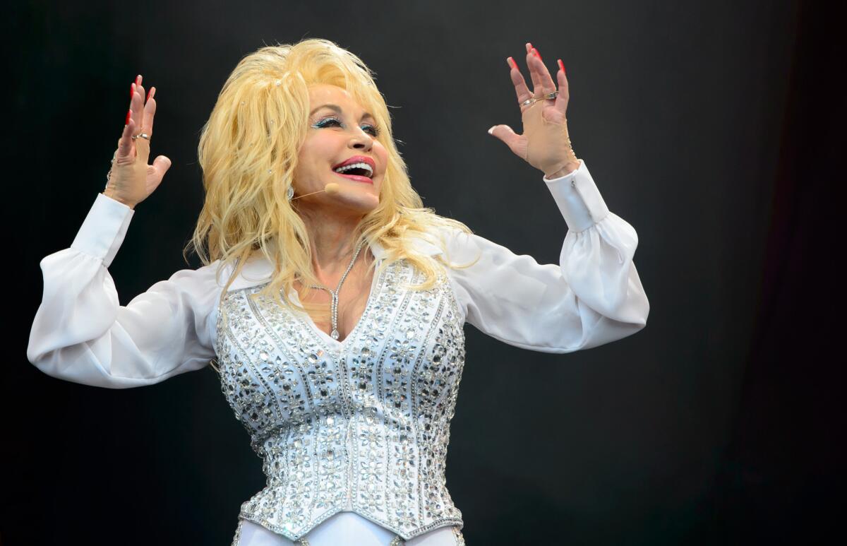 Dolly Parton performs at the Glastonbury Festival in England last June. On Friday, NBC announced that it had signed a deal to develop a slate of TV movies "based on the songs, stories and inspiring life" of the country music legend.