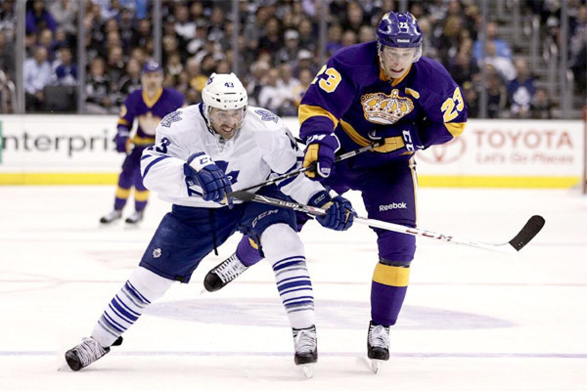 Dustin Brown and the Maple Leafs' Nazem Kadri, left, chase after the puck during the second period of the Kings' 3-2 loss Thursday to Toronto.