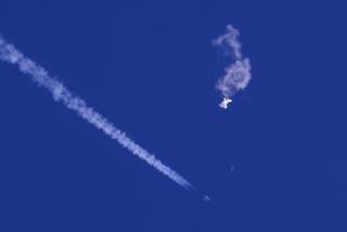 FILE - In this photo provided by Chad Fish, the remnants of a large balloon drift above the Atlantic Ocean, just off the coast of South Carolina, with a fighter jet and its contrail seen below it, Feb. 4, 2023. A missile fired on Feb. 5 by a U.S. F-22 off the Carolina coast ended the days-long flight of what the Biden administration says was a surveillance operation that took the Chinese balloon near U.S. military sites. It was an unprecedented incursion across U.S. territory for recent decades, and raised concerns among Americans about a possible escalation in spying and other challenges from rival China. (Chad Fish via AP, File)