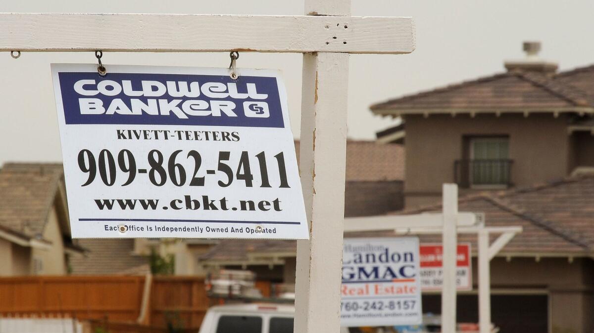 For-sale signs line a residential street in Adelanto. Last month, state lawmakers sought to block a court ruling to repay $331 million from a national settlement of claims during the mortgage and foreclosure crisis.