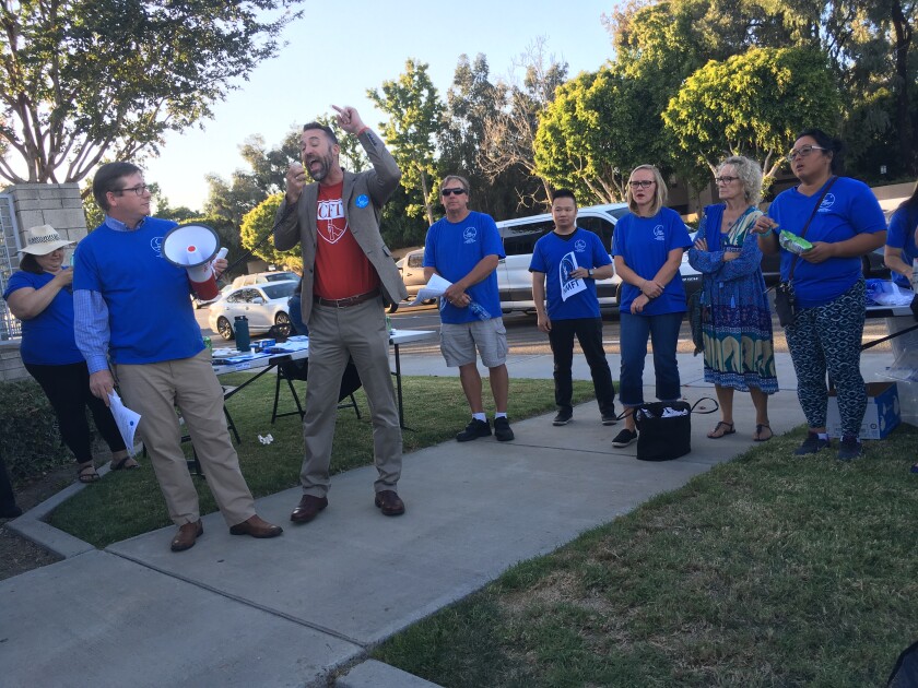 Newport-Mesa Federation of Teachers President Britt Dowdy, left, and Jeff Freitas, president of the California Federation of Teachers, rally Newport-Mesa teachers before a school board meeting in October.
