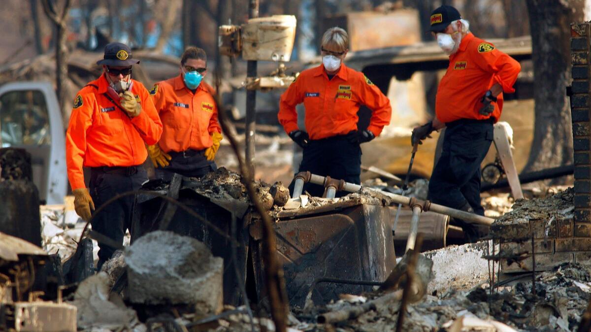 Looking for remains of firestorm victims is slow, tedious work. In Santa Rosa, members of a team pause as they decide which area to search.