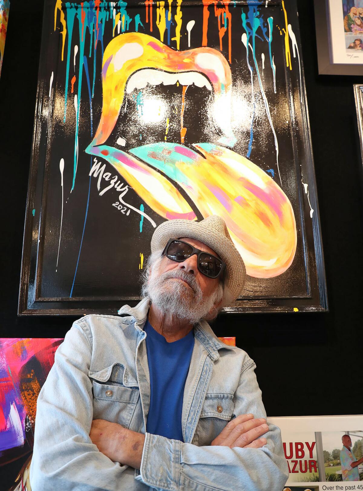 Ruby Mazur stands with one of his iconic mouth-and-tongue pieces in the Bill Mack Gallery in Laguna Beach.