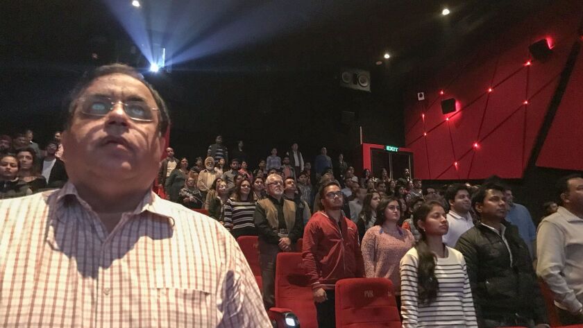 Audience members stand for the Indian national anthem before a movie starts at a cinema in New Delhi on December 4, 2016.