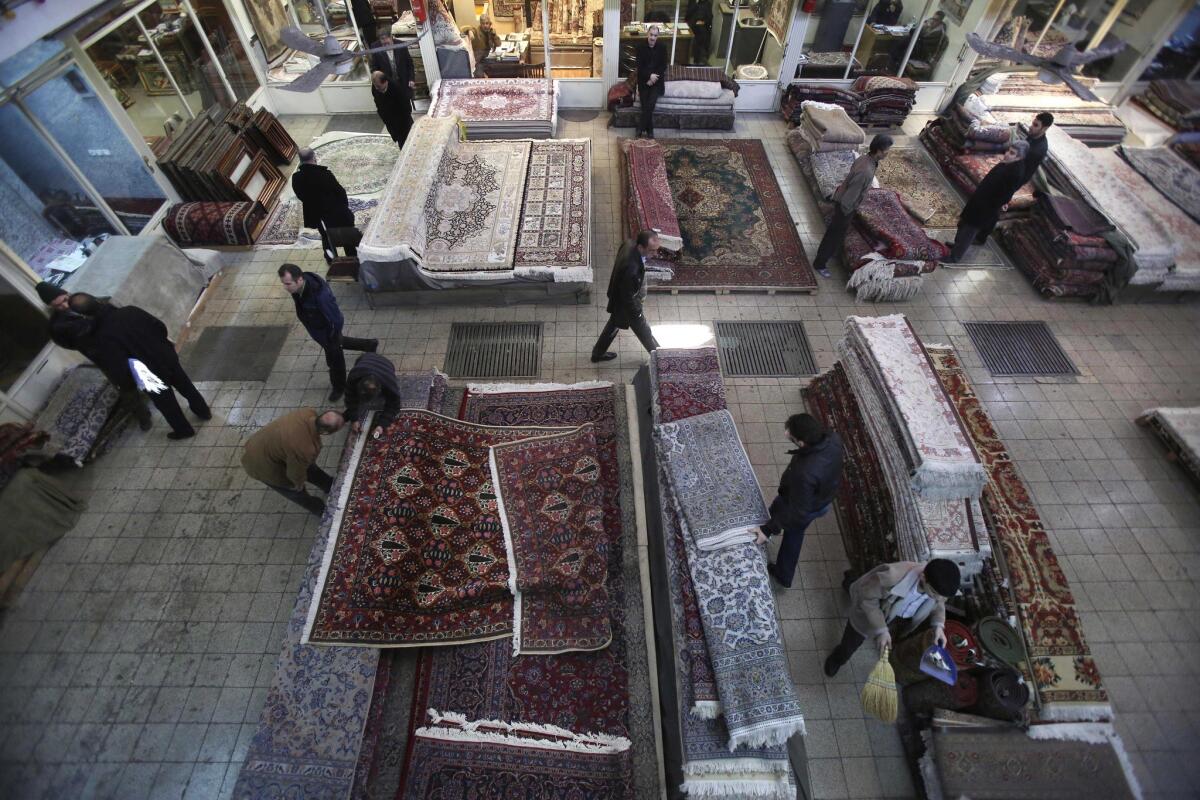 Iranian carpet merchants display their wares at a shopping center in Tehran in January. Businesspeople hurt by international sanctions have been studying the progress of the nuclear talks with hope and dread.