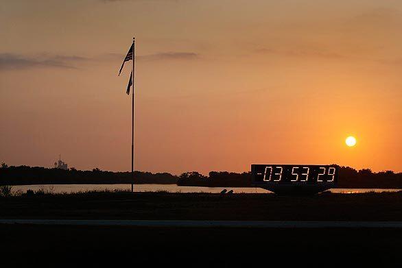 The sun rises over the launch clock as the space shuttle Atlantis prepares for an 11:01 a.m. (PST) launch at Kennedy Space Center in Cape Canaveral, Fla.