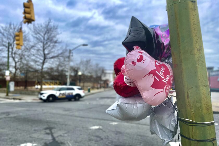 Balloons are placed at a utility pole at the site of Saturday's shooting in west Baltimore's Upton neighborhood on Monday, Jan. 30, 2023. A weekend shooting in west Baltimore’s Upton neighborhood killed two people and left three others injured, including two young children whose mother was hospitalized in critical condition and later died. (AP Photo/Lea Skene)