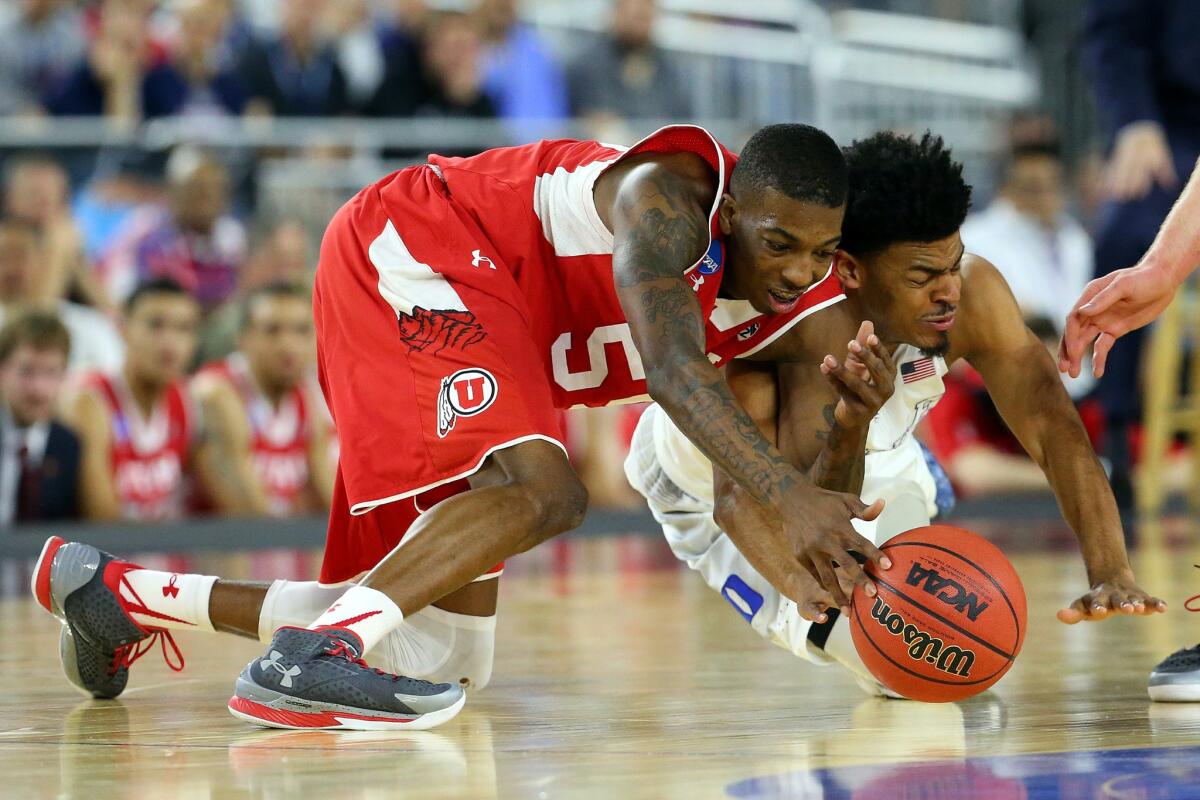 Utah guard Delon Wright and Duke guard Quinn Cook dive after a loose ball during their NCAA South Regional semifinal game on Friday night in Houston.