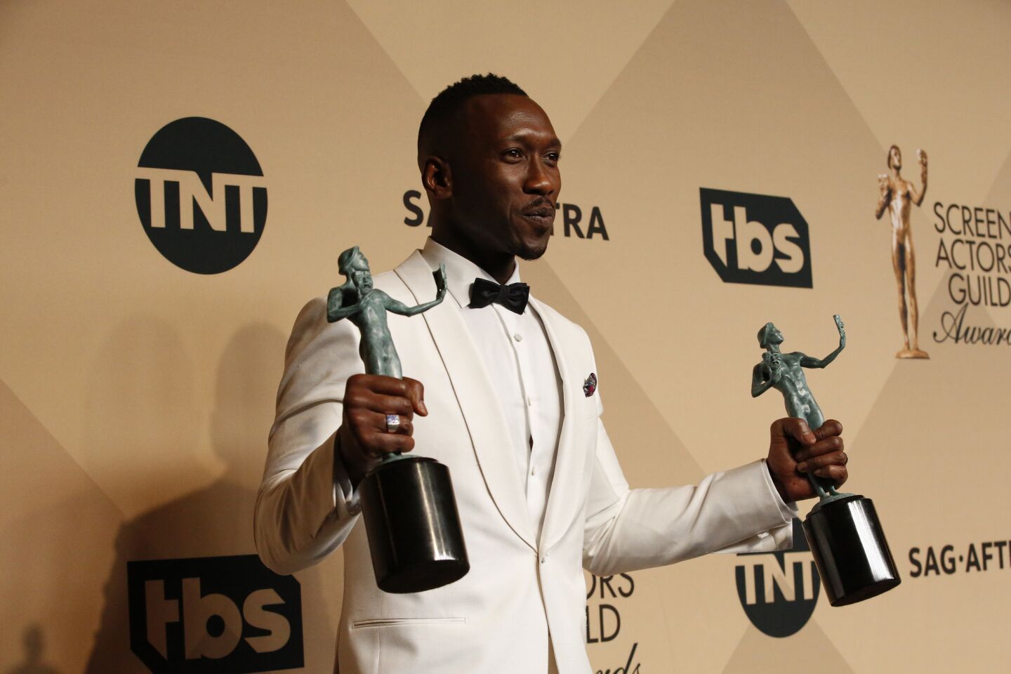 Mahershala Ali holds his awards for supporting actor in "Moonlight" as well as his award for "Hidden Figures," which won an ensemble award.
