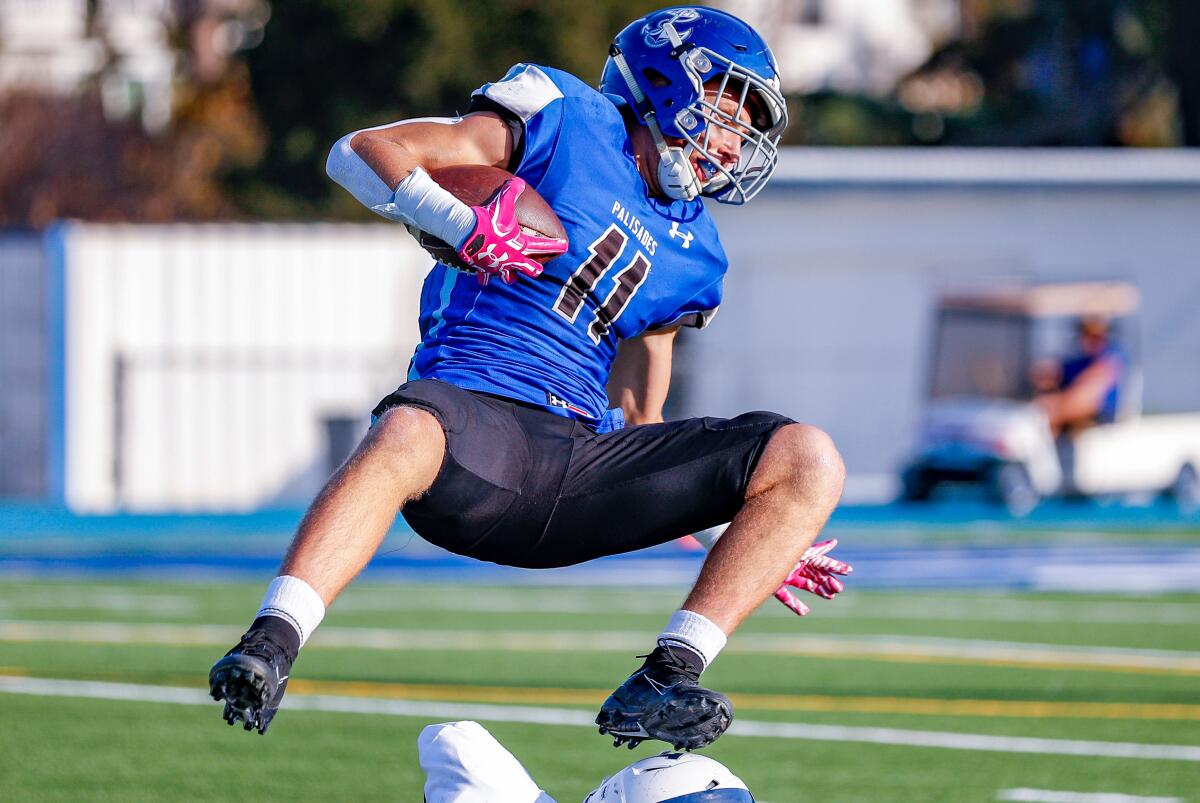 Palisades running back Max Palees gets up ended after catching a pass in the first half of Palisades' win over Venice on Monday.